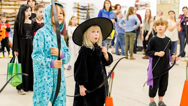Kids in costume shooting bows at Track-or-Treat